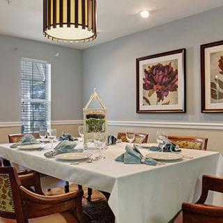 An elegantly set dining table in a stylishly decorated room with artwork on the walls.