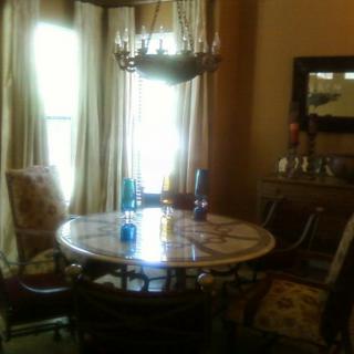 A cozy dining room with a round table and chandelier.