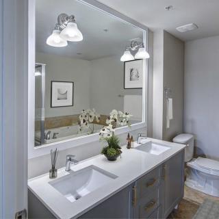 A modern bathroom with a double sink and decorative plants.