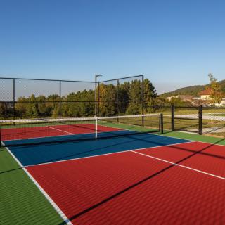 An empty outdoor sports court under a clear blue sky.