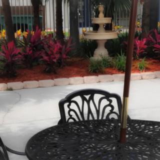 A peaceful garden patio with decorative furniture and a fountain.