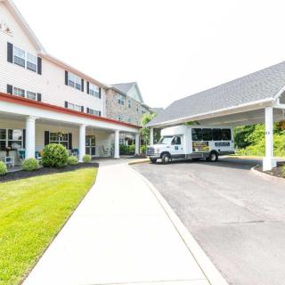 A residential building with a driveway and a parked vehicle.