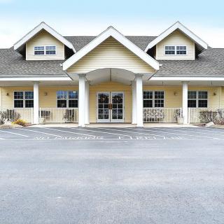 A two-story residential building with a prominent entrance and porch.