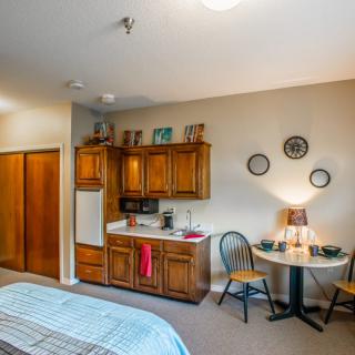 A cozy room with a kitchenette and a small dining area.