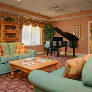 A cozy living room with a grand piano and comfortable seating.