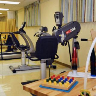 A rehabilitation room equipped with exercise machines and therapy tools.