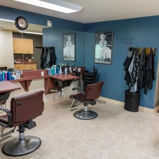 A tidy barbershop interior with chairs, mirrors, and hair styling products.