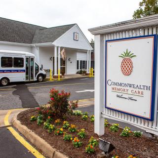 Entrance of a retirement home with a sign and transport vehicle.
