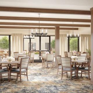 A spacious dining room with wooden furniture and elegant chandeliers.