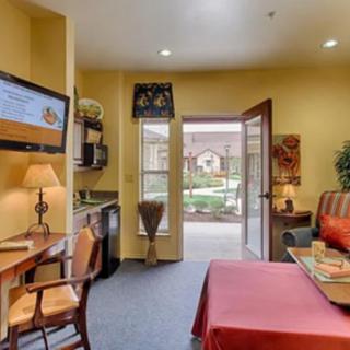 A cozy hotel room with a desk, television, and patio access.