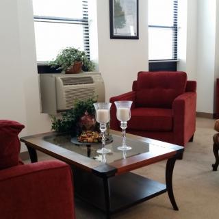 A cozy living room with red chairs and a decorative coffee table.