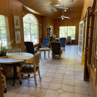 A sunlit room with various seating arrangements and large windows.