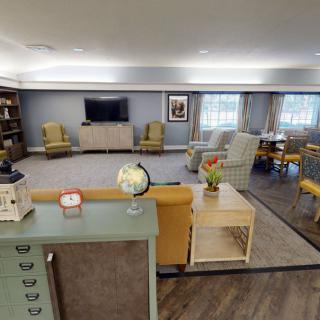 A cozy living room with comfortable seating, a television, and decorative items like a globe and lamp.