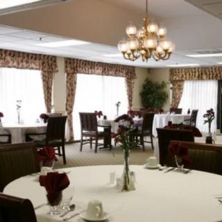 A well-decorated dining room featuring elegant table settings and a chandelier.