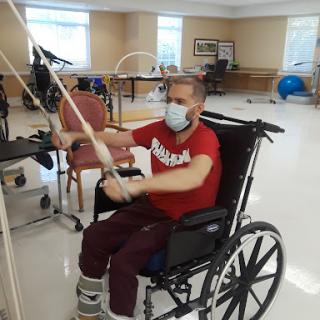 A patient engaged in physical therapy exercises while seated in a wheelchair.