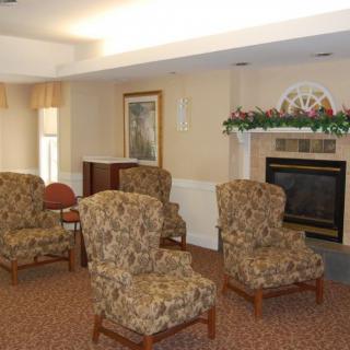 A cozy living room with patterned chairs, a fireplace, and elegant decor.