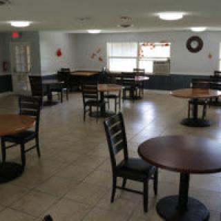 An empty cafeteria with several tables and chairs arranged neatly.