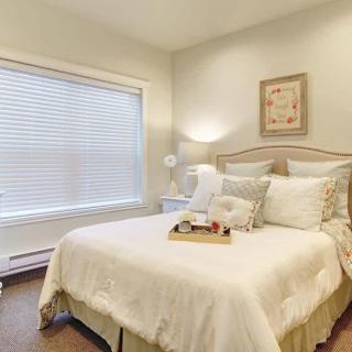 A cozy and elegantly decorated bedroom with neutral tones and soft lighting.