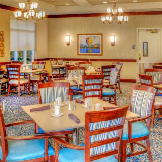 A well-lit dining area with neatly arranged tables and chairs.