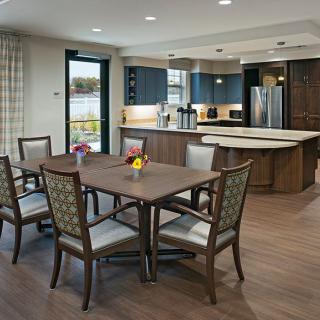 A modern kitchen and dining area with a wooden table, chairs, and contemporary decor.