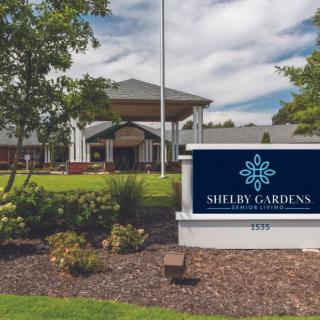 Entrance of Shelby Gardens surrounded by lush greenery.