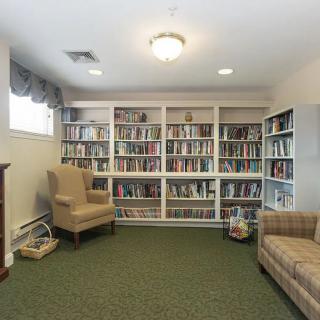 A cozy reading room with bookshelves and comfortable chairs.