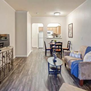 A modern apartment living room with an open kitchen and dining area.