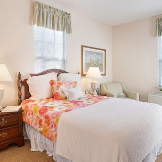A cozy bedroom with a floral-patterned bedspread and soft lighting.