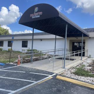 The entrance of a building featuring a ramp for accessibility, covered by a canopy.