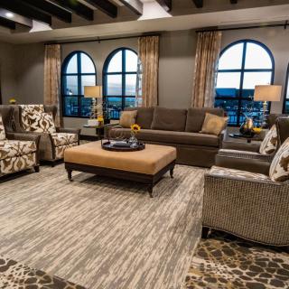A cozy living room with elegant furnishings and large arched windows.