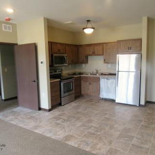 A modern apartment kitchen featuring stainless steel appliances and an open floor plan.
