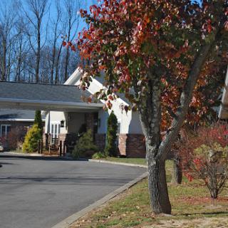 A serene view of a residential building surrounded by autumn foliage.