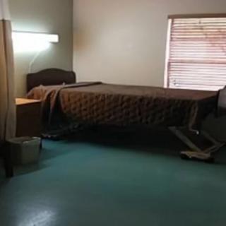 A hospital room with a bed and a window.