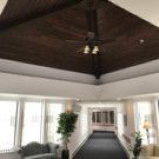 A spacious lobby area with large windows, wooden ceiling, and modern furnishings.