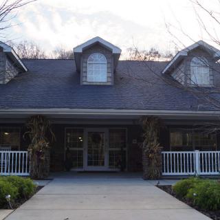 A two-story house with a porch and dormer windows.