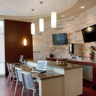 A sleek and modern lobby area featuring workstations, contemporary lighting, and stylish furnishings.