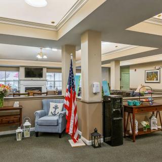 A cozy lobby area featuring seating, decorative elements, and an American flag.