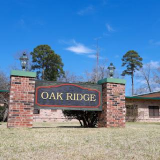 Entrance sign of Oak Ridge with a clear blue sky in the background.