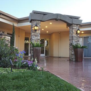 A beautifully designed entrance to a modern home, featuring elegant landscaping and warm lighting.