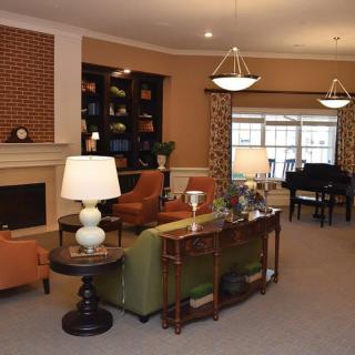 A cozy living room with a fireplace, bookshelves, and comfortable seating.