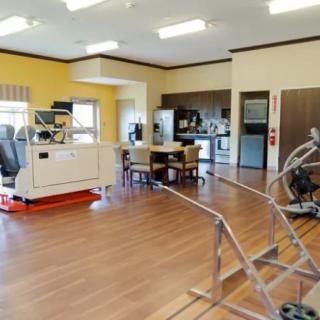 A spacious rehabilitation therapy room equipped with various exercise machines and medical equipment.