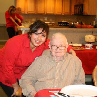 A joyful moment shared between a woman and a senior man during a gathering.