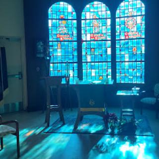 A serene church interior illuminated by colorful stained glass windows.