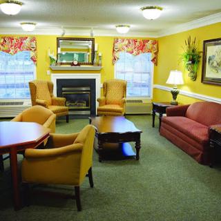A cozy living room featuring yellow walls, comfortable seating, and a fireplace.
