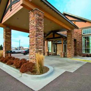 The entrance of a commercial building with brick columns and large windows.