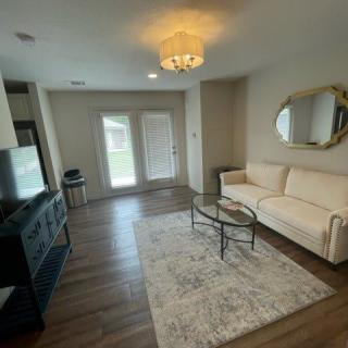 A modern living room with a large sofa, flat-screen TV, and stylish decor.