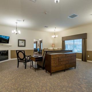 A spacious living room featuring a large sofa, chairs, a fireplace, and a mounted TV with elegant interior design elements.