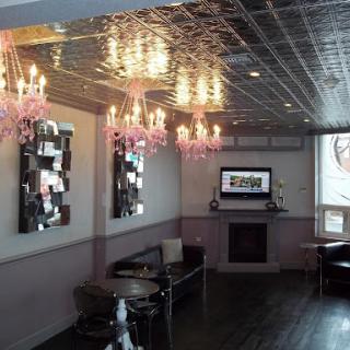 A stylish and modern lounge interior featuring elegant chandeliers and mirrors.