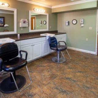 An interior view of a salon with chairs and mirrors.