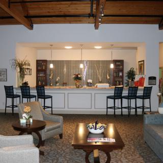 A cozy living room with comfortable seating and a kitchen counter in the background.